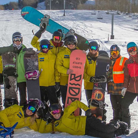 Group of snowboarders on top of a mountain 