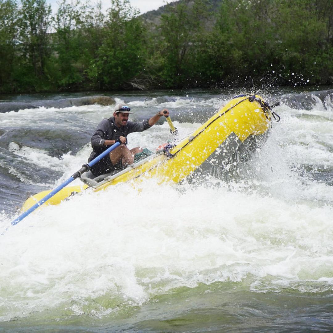 Antonio rowing a raft through a rapid.