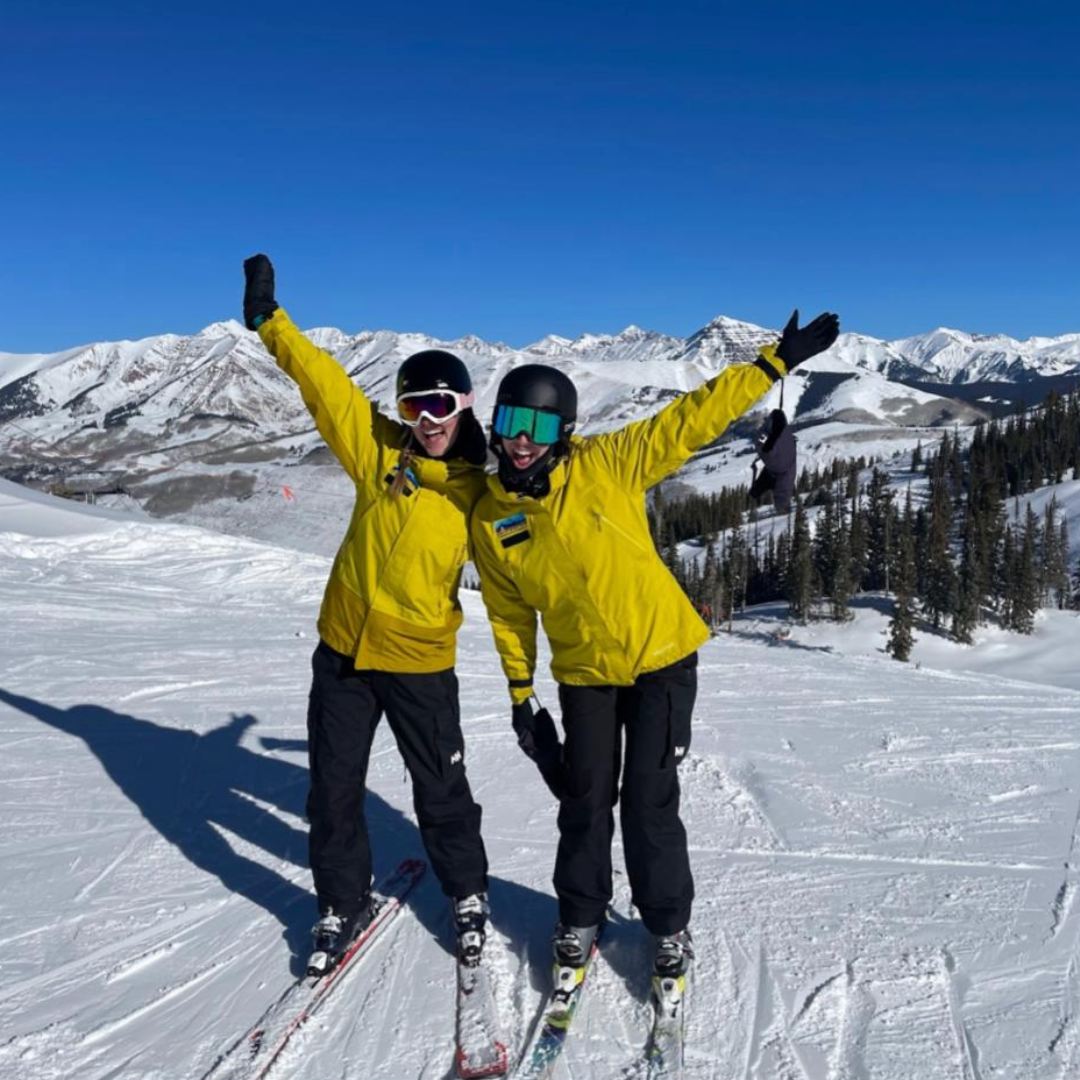 Photo of Emily with another intern on top of ski hill.