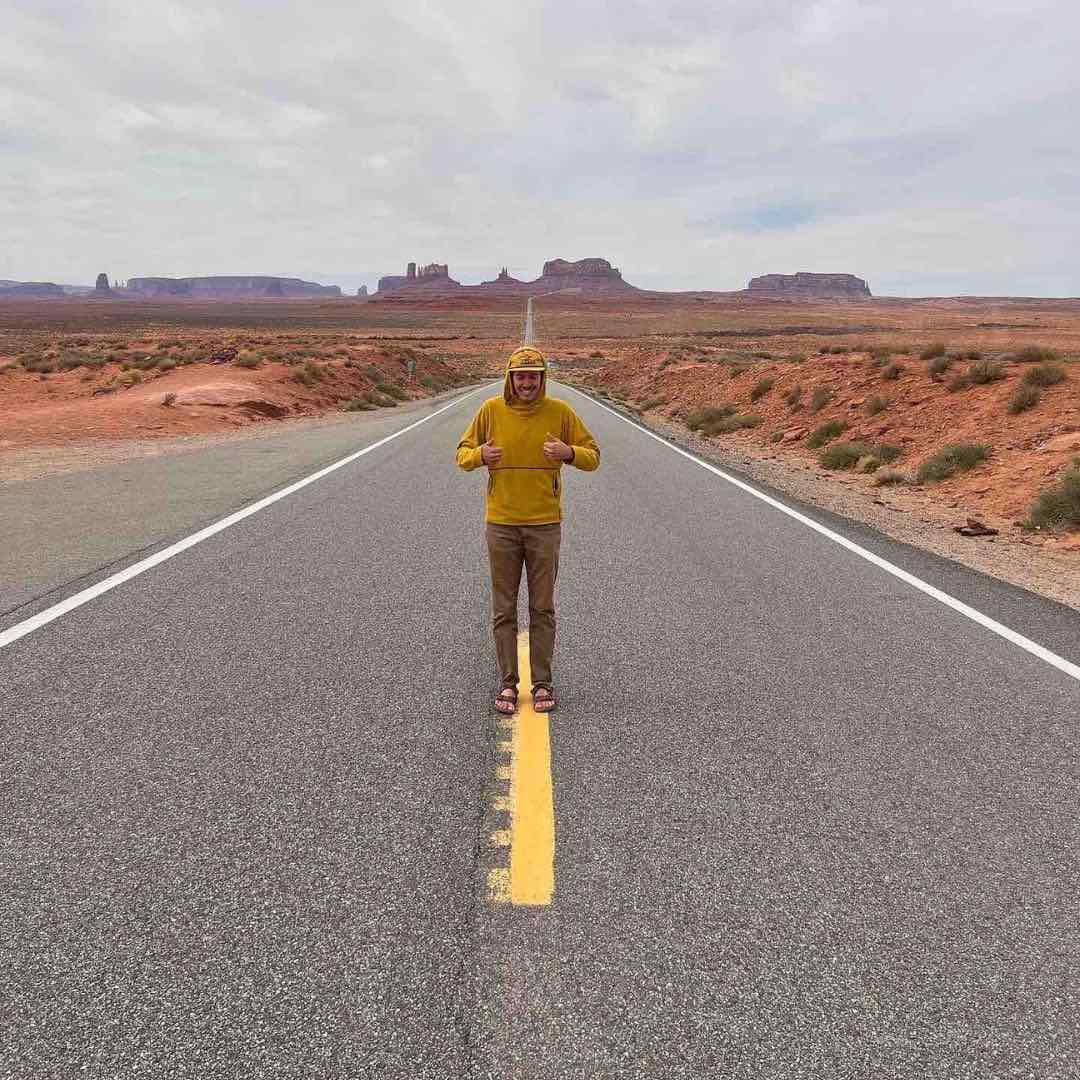 Antonio smiling while on a road in the Utah desert.