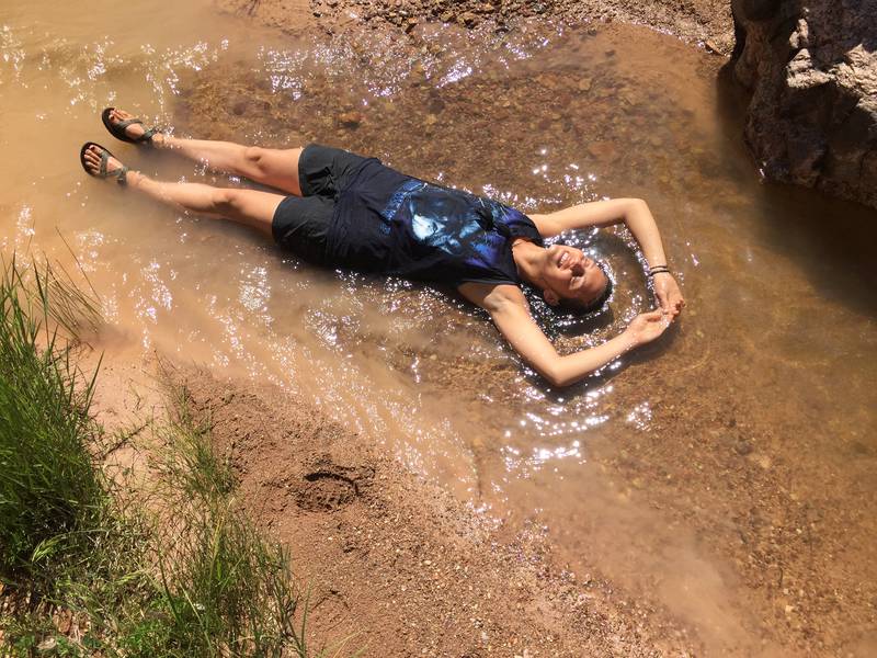 hiker laying in a stream