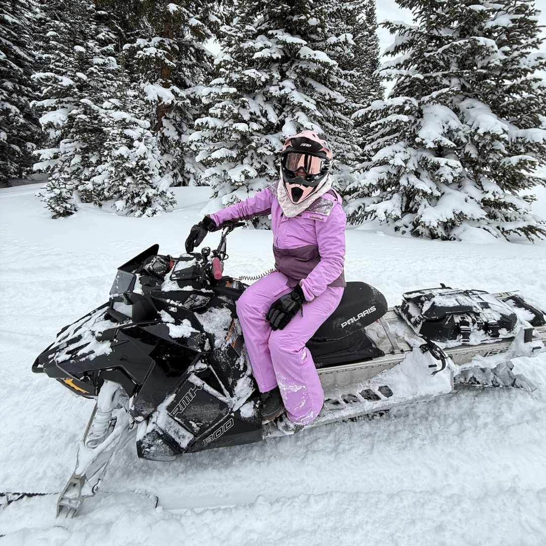 Jessica smiling on her snowmobile.