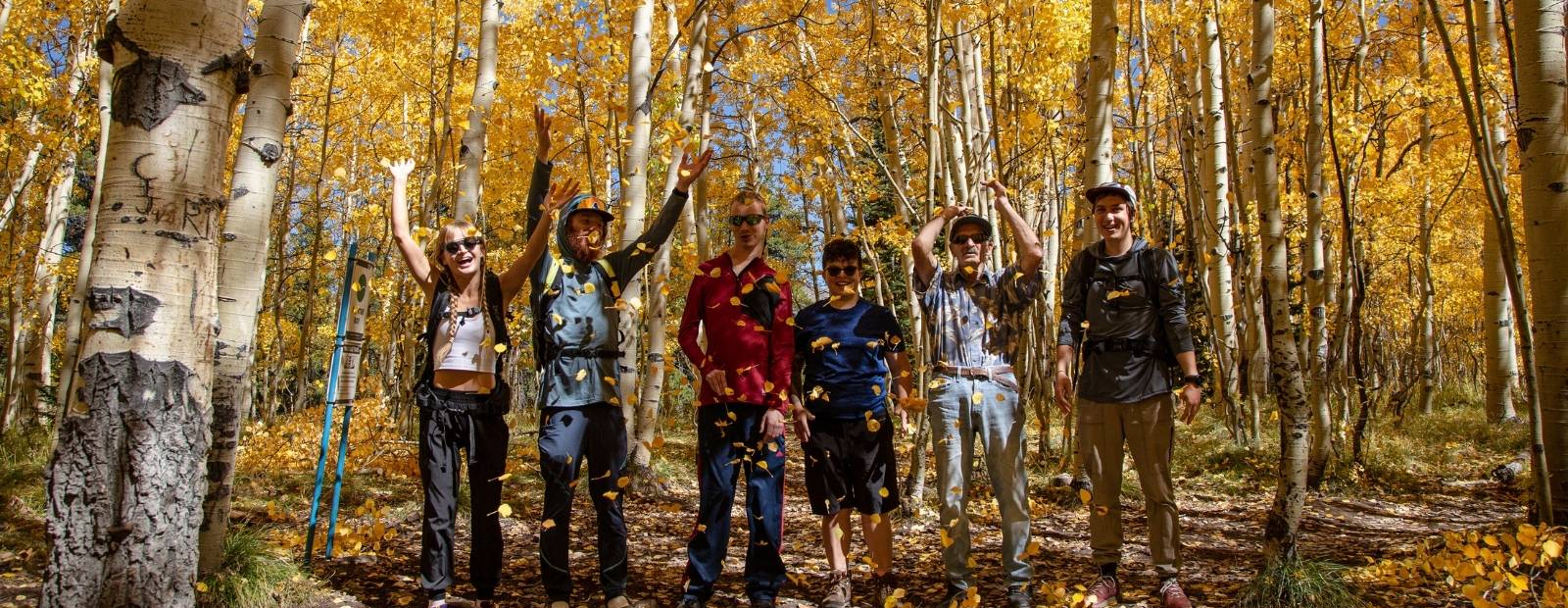 Photo of prople throwing leaves in the air.