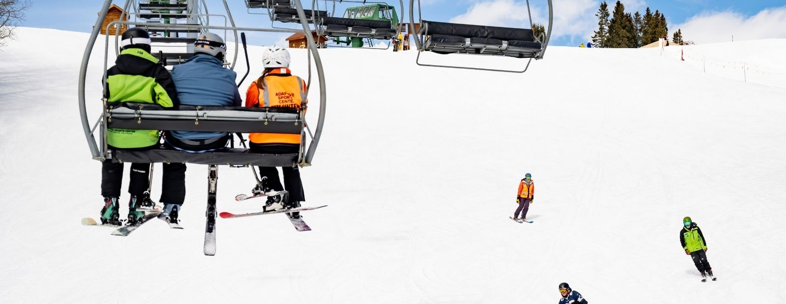 slider on chairlift with sit skier in background 